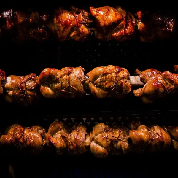 Rows of rotisserie chickens turning on spits